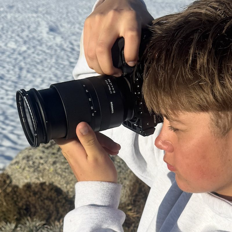 Close up of Finn framing a shot with his camera